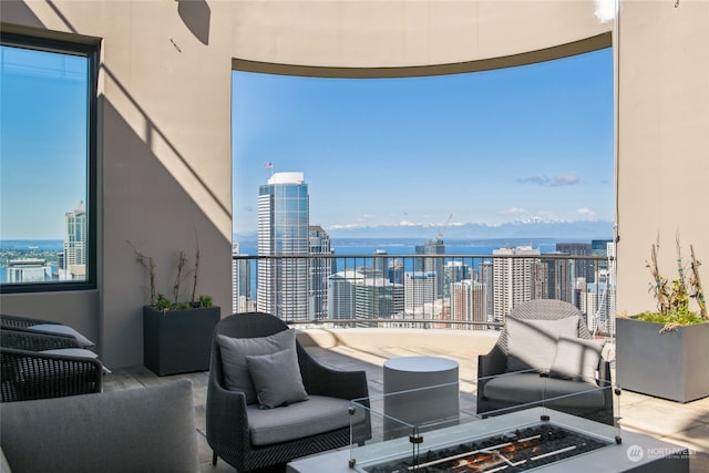 balcony with an outdoor living space and a water view