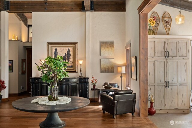 living area featuring beam ceiling and wood-type flooring