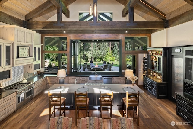 kitchen with dark wood-type flooring, a breakfast bar area, vaulted ceiling with beams, wood ceiling, and a kitchen island