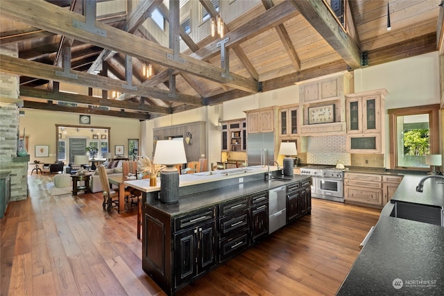 kitchen with high end appliances, sink, hardwood / wood-style floors, and cream cabinetry