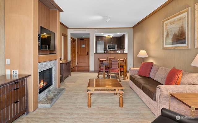 living room with crown molding and a fireplace