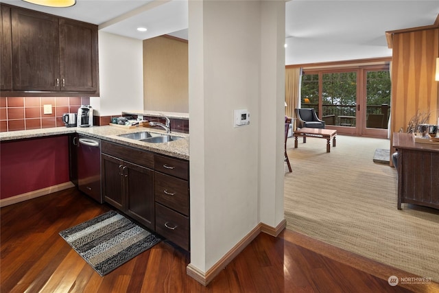 kitchen with light stone countertops, tasteful backsplash, stainless steel dishwasher, sink, and dark brown cabinets