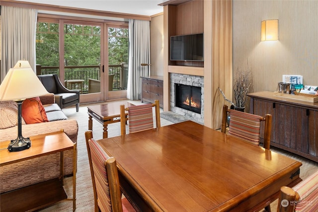 living room featuring crown molding and a stone fireplace