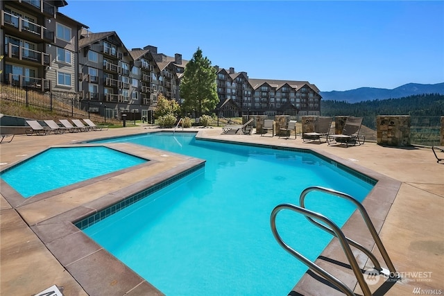 view of pool with a mountain view and a patio