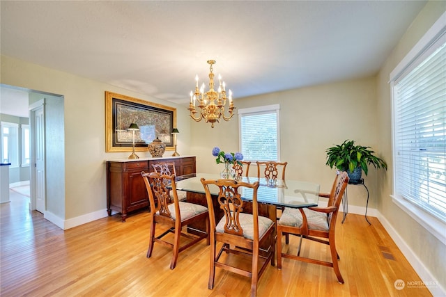 dining space with a notable chandelier, light wood-type flooring, and baseboards