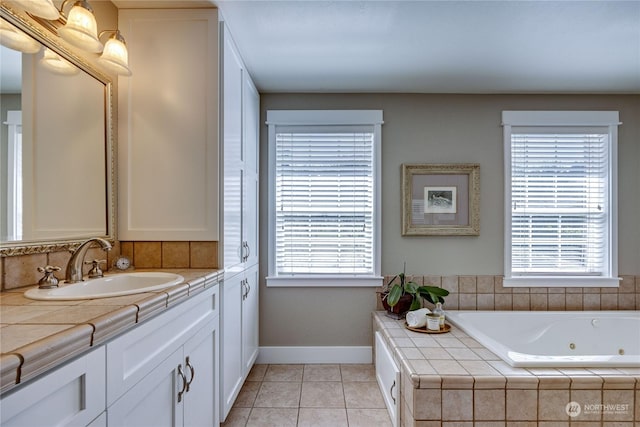 bathroom with a whirlpool tub, tile patterned flooring, vanity, and baseboards