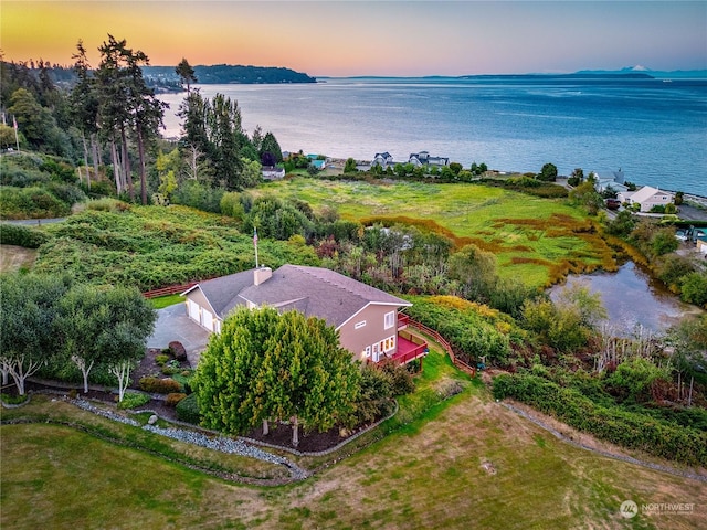 aerial view at dusk featuring a water view