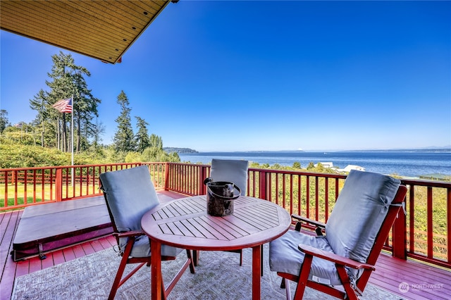 wooden terrace featuring a water view and outdoor dining space