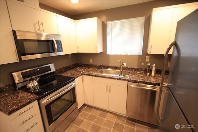 kitchen featuring stainless steel appliances, tile patterned floors, white cabinets, and sink