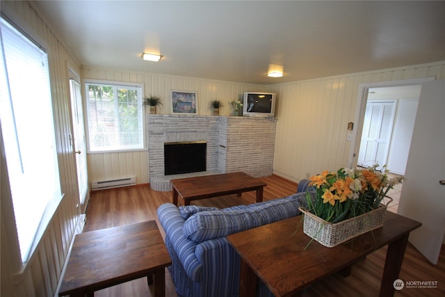 living room featuring a brick fireplace, hardwood / wood-style floors, and a baseboard radiator