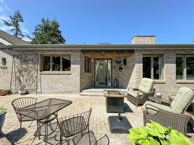 rear view of house with a patio and a fire pit