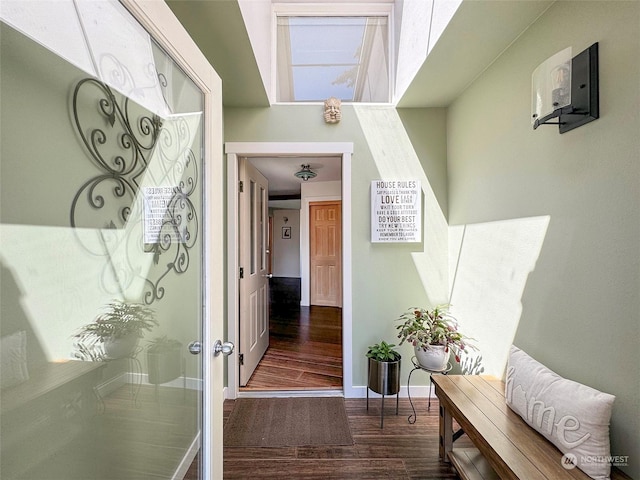 hallway with wood finished floors and baseboards