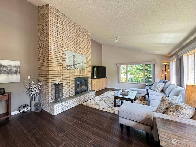 living room with baseboards, a textured ceiling, wood finished floors, and a fireplace