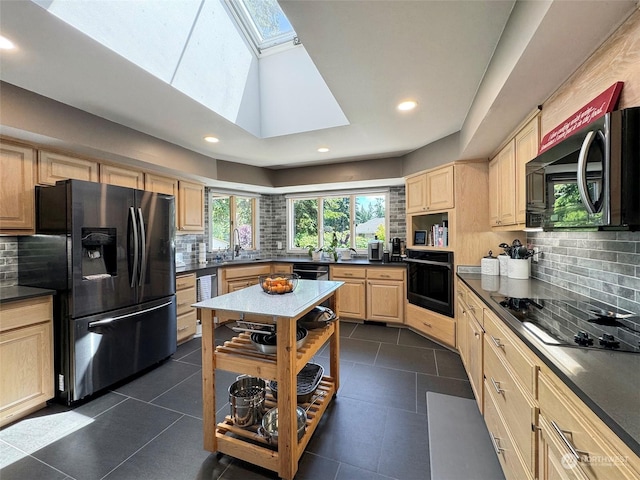 kitchen with black appliances, dark countertops, and light brown cabinetry