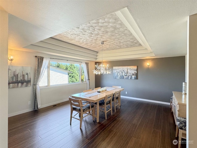 dining space with baseboards, a raised ceiling, dark wood-type flooring, and a textured ceiling