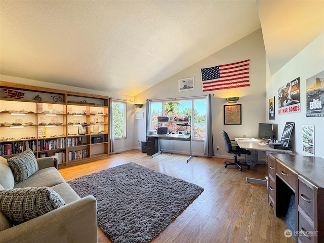 office area with high vaulted ceiling, a textured ceiling, baseboards, and wood finished floors