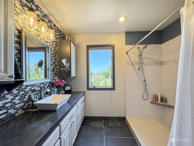 full bath with a tile shower, backsplash, baseboards, and a wealth of natural light