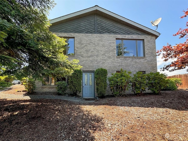 exterior space featuring brick siding and fence