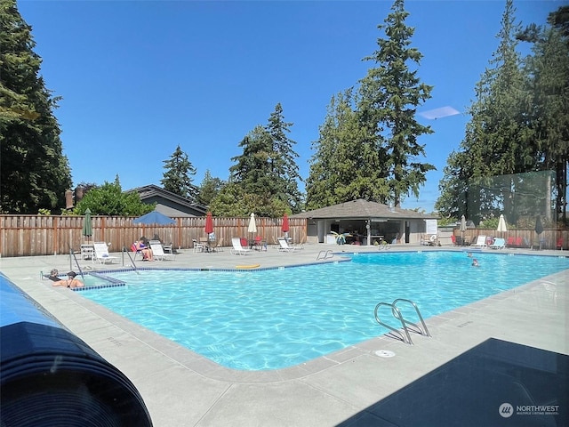 pool with a patio area and fence