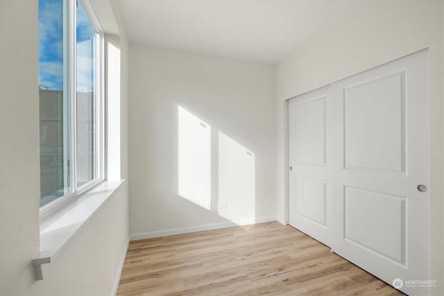 unfurnished bedroom with a closet and light hardwood / wood-style flooring