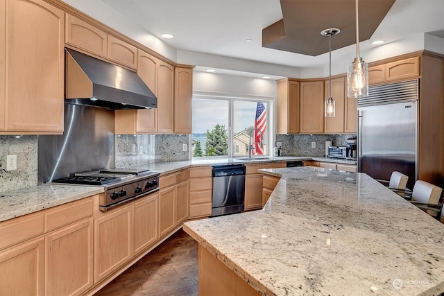 kitchen featuring light stone countertops, stainless steel appliances, light brown cabinets, pendant lighting, and range hood