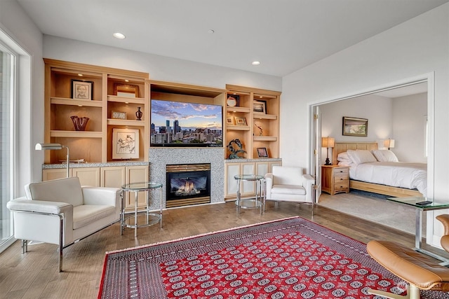 interior space with built in shelves and hardwood / wood-style floors