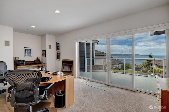 office with light carpet and a water view