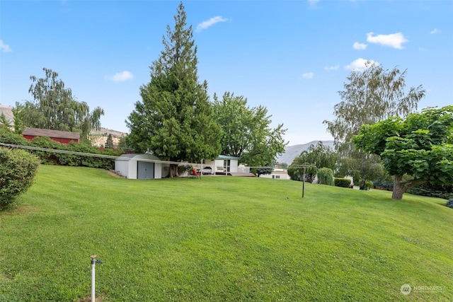 view of yard with a mountain view and a storage shed