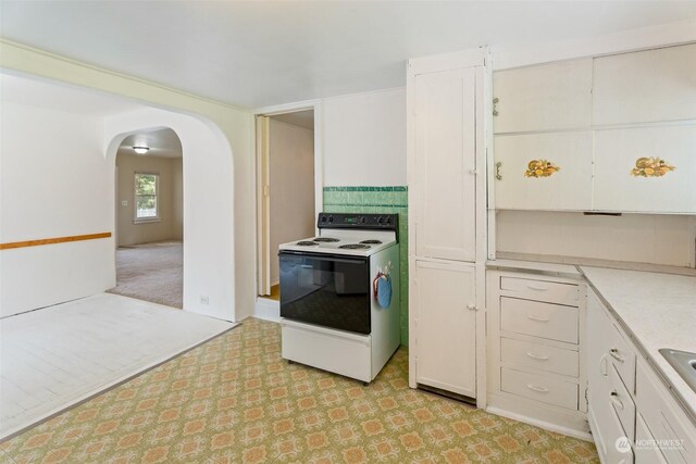 kitchen featuring white cabinets and electric range