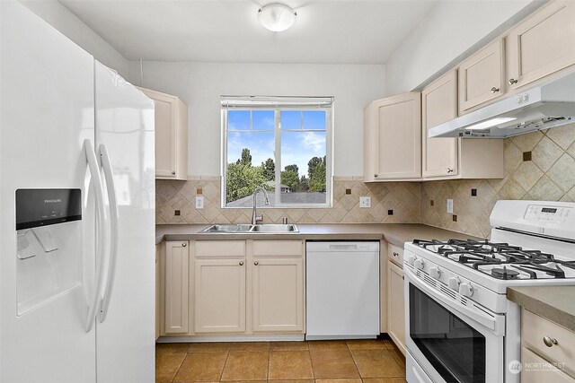 kitchen with tasteful backsplash, sink, white appliances, and light tile patterned floors