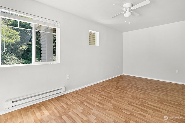 spare room featuring a baseboard heating unit, hardwood / wood-style floors, and ceiling fan