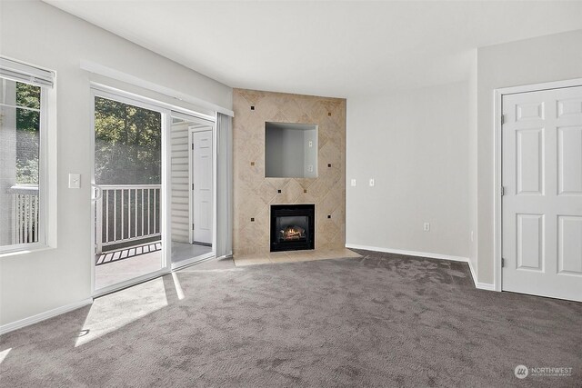 unfurnished living room featuring dark colored carpet and a large fireplace