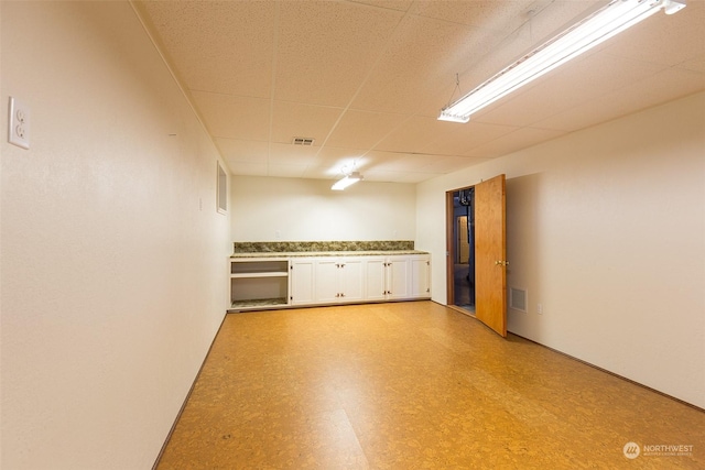 basement featuring a paneled ceiling