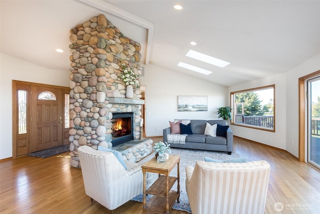 living room featuring hardwood / wood-style floors, vaulted ceiling, and a fireplace