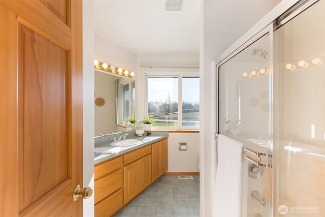 bathroom with vanity and a shower with shower door