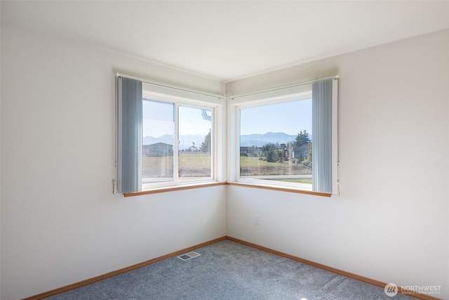 carpeted empty room featuring a mountain view