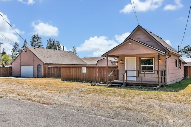 bungalow featuring a garage, an outbuilding, and a front yard