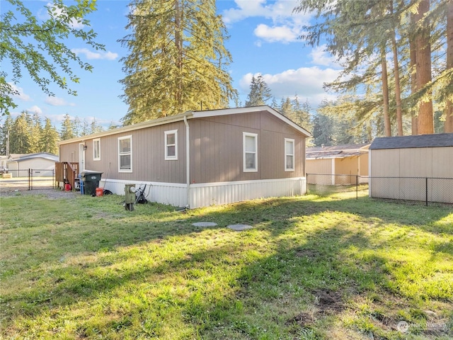 view of side of home featuring a lawn and a shed