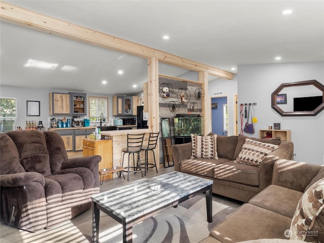 living room featuring beam ceiling and light wood-type flooring