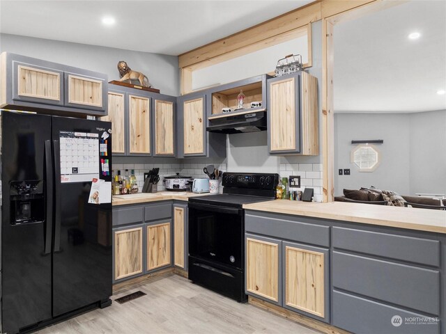 kitchen featuring black appliances, gray cabinetry, light wood-type flooring, and light brown cabinetry