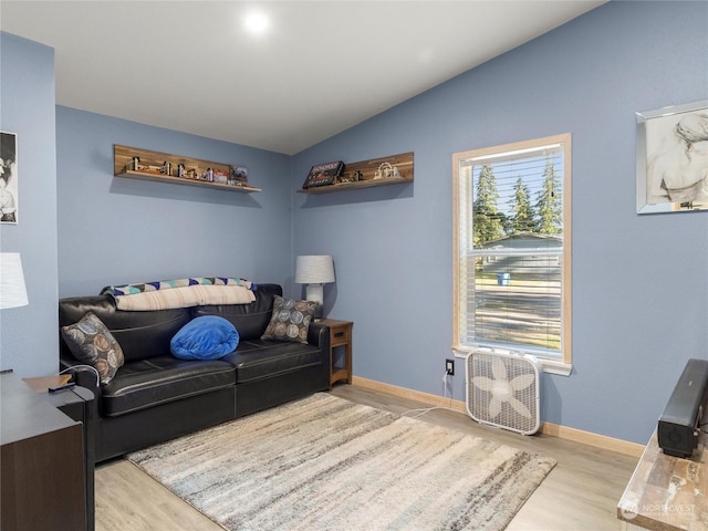 living room featuring vaulted ceiling and light hardwood / wood-style flooring