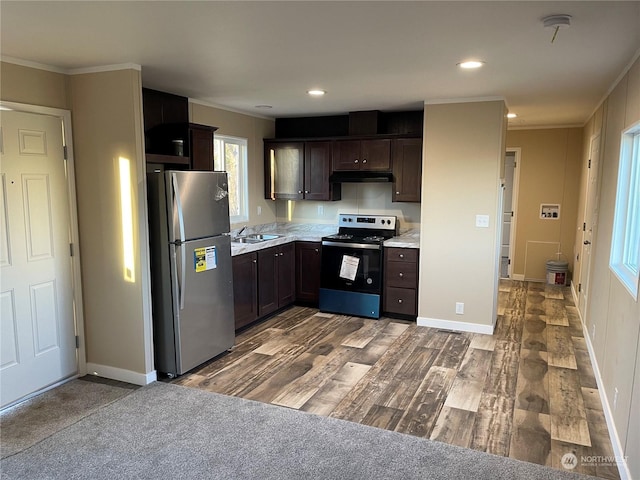 kitchen featuring dark brown cabinetry, sink, appliances with stainless steel finishes, ornamental molding, and hardwood / wood-style flooring