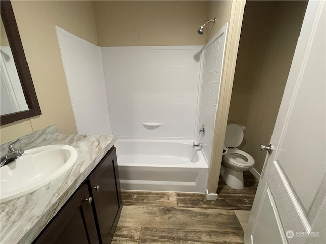 full bathroom featuring hardwood / wood-style flooring, vanity, washtub / shower combination, and toilet