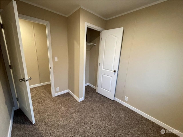 unfurnished bedroom with crown molding, a closet, and dark colored carpet