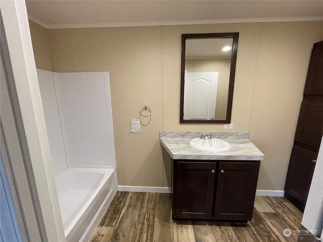 bathroom with hardwood / wood-style flooring, vanity, shower / washtub combination, and ornamental molding