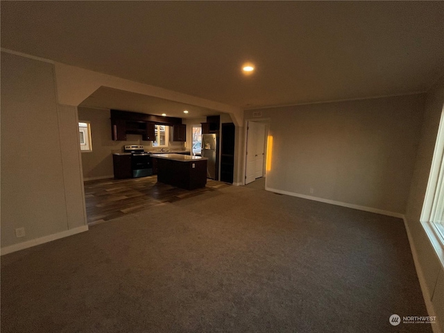 unfurnished living room with dark colored carpet