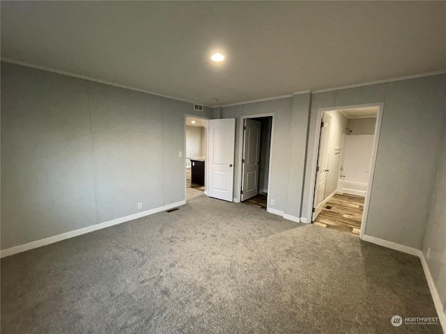 unfurnished bedroom featuring crown molding, carpet, and connected bathroom