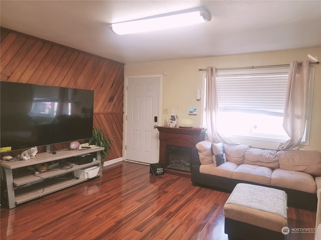 living room featuring dark wood-type flooring and wooden walls