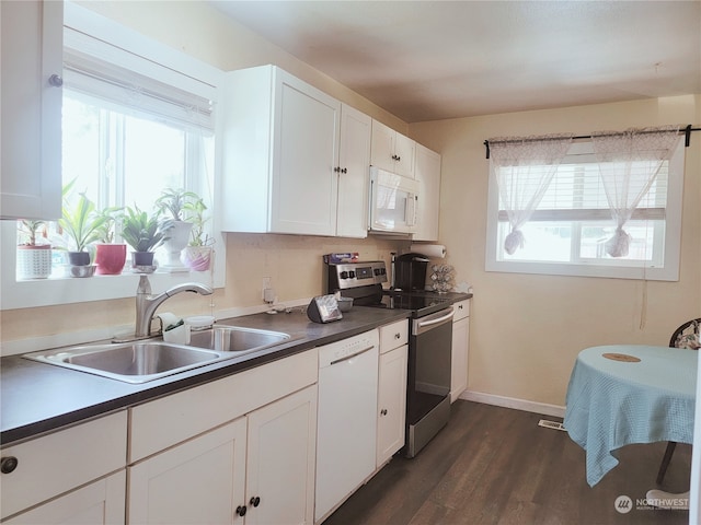 kitchen with white cabinetry, sink, white appliances, and a wealth of natural light