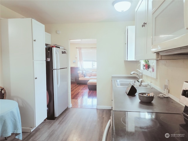 kitchen featuring sink, white fridge, electric stove, light hardwood / wood-style floors, and white cabinets